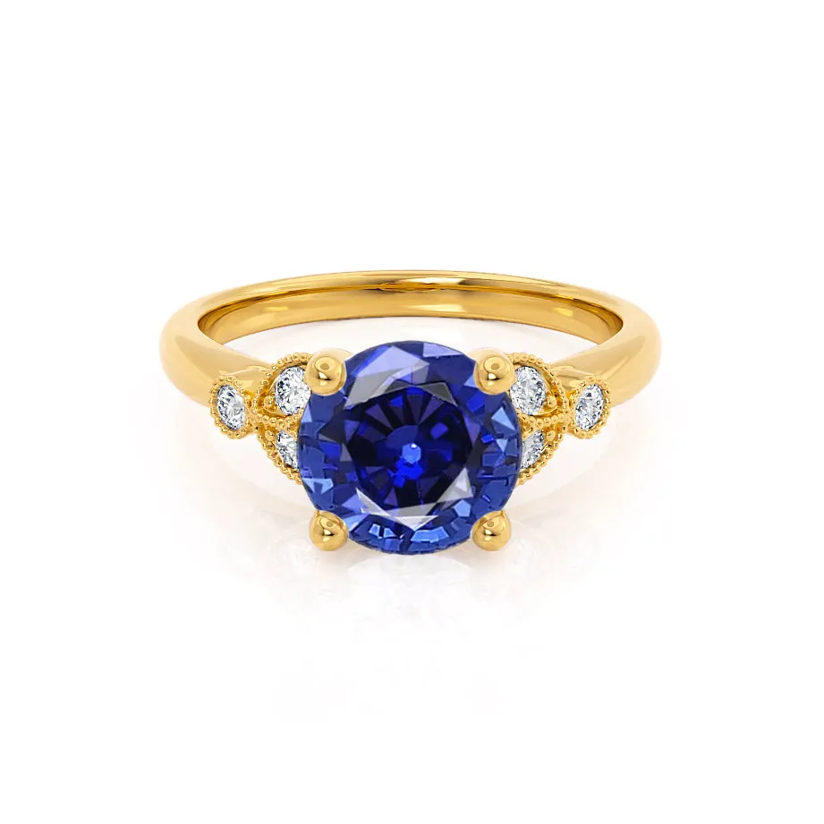 DELILAH - Chatham® Round Blue Sapphire 18k Yellow Gold Shoulder Set Ring